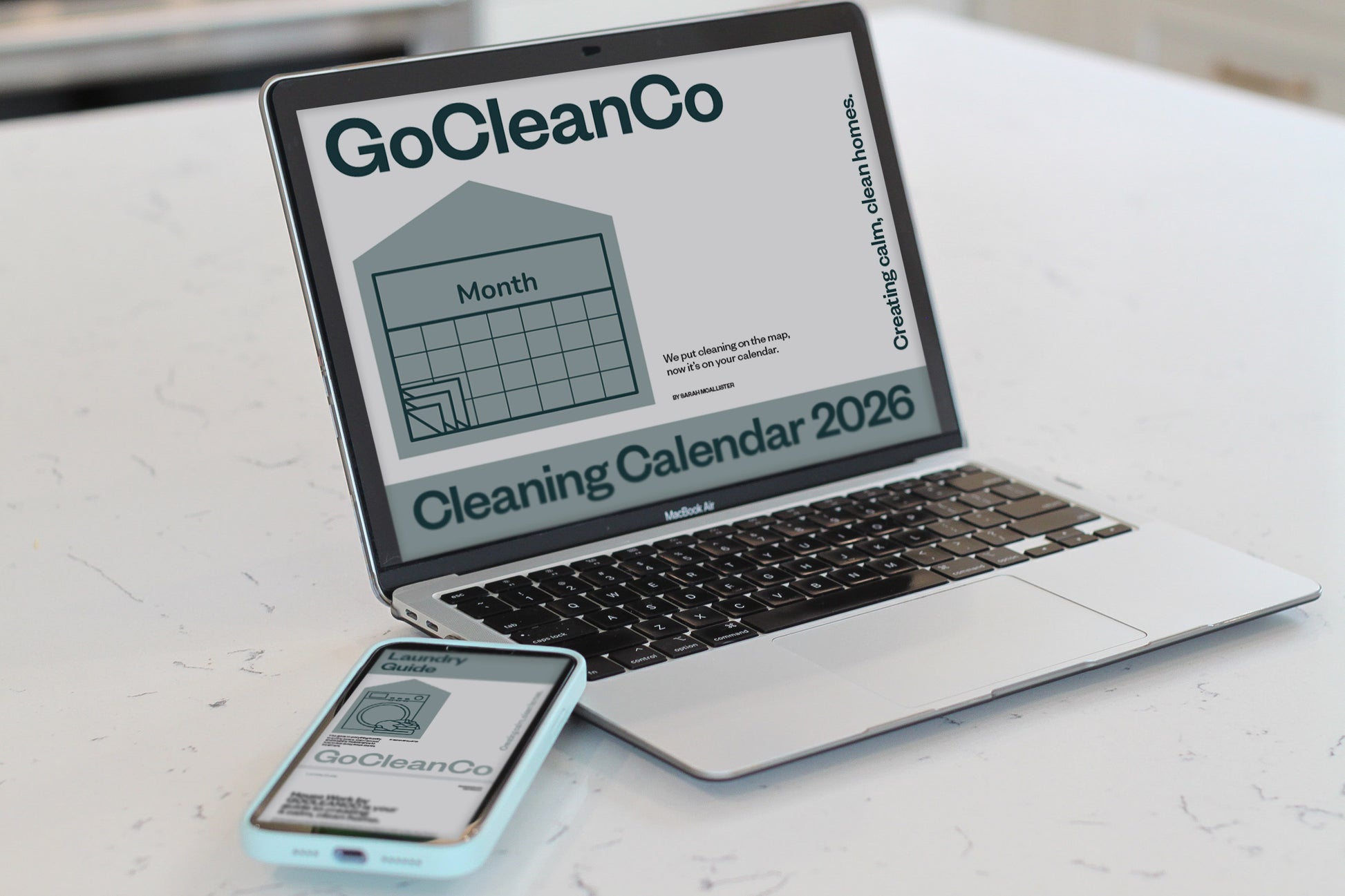 Laptop and smartphone displaying GoCleanCo cleaning calendar and laundry guide on a white background