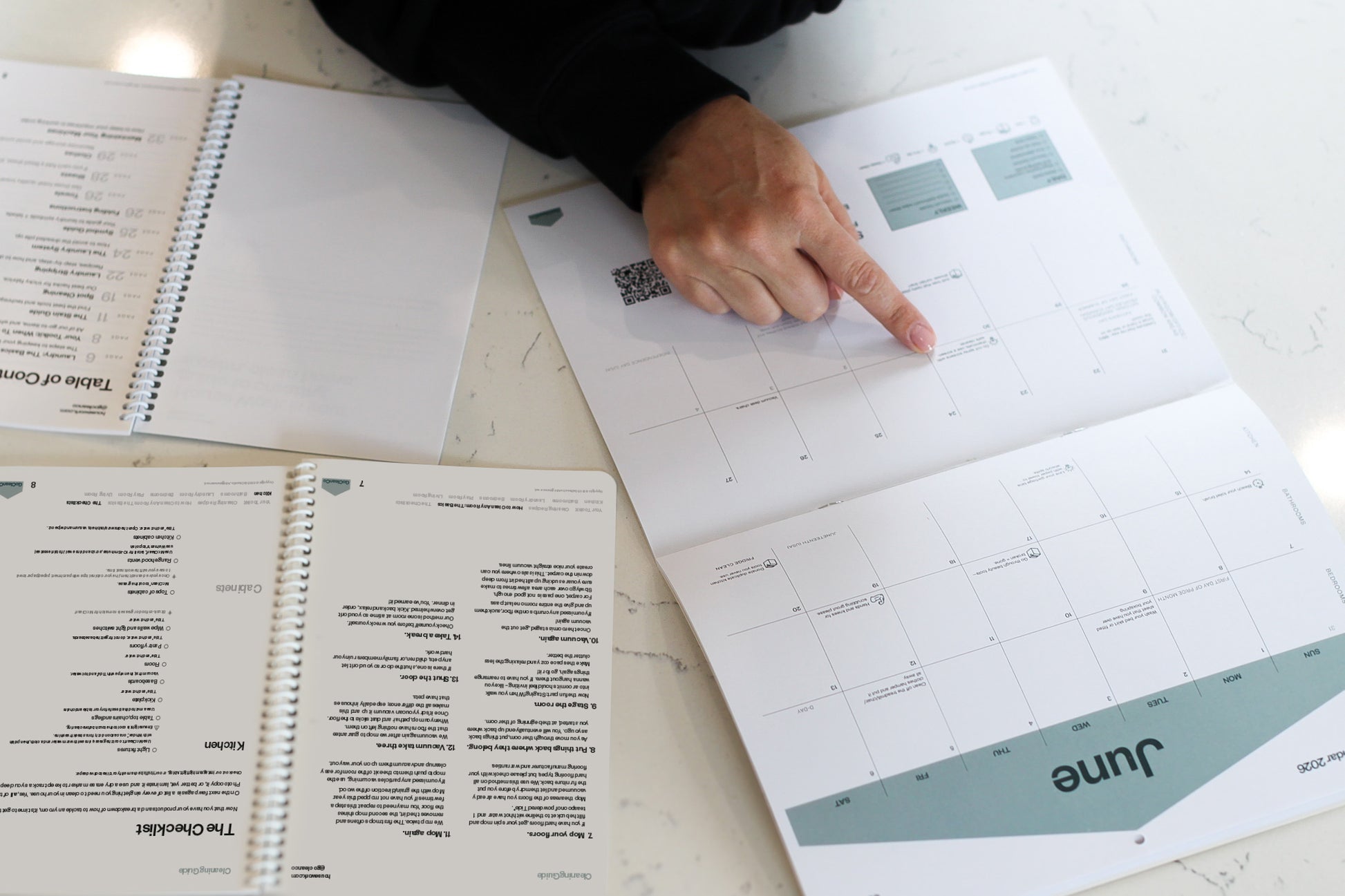Person pointing at a cleaning calendar with June on a counter