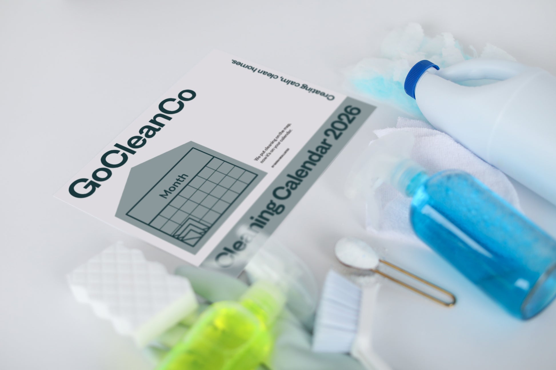 Cleaning supplies including a bottle, brush, and calendar with 'GoCleanCo' branding on a light background.