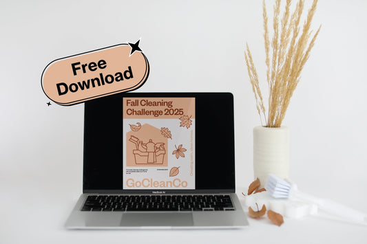 A laptop displays a digital flyer for a "Fall Cleaning Challenge 2025" from GoCleanCo, featuring a minimalist illustration of cleaning supplies and autumn leaves.
