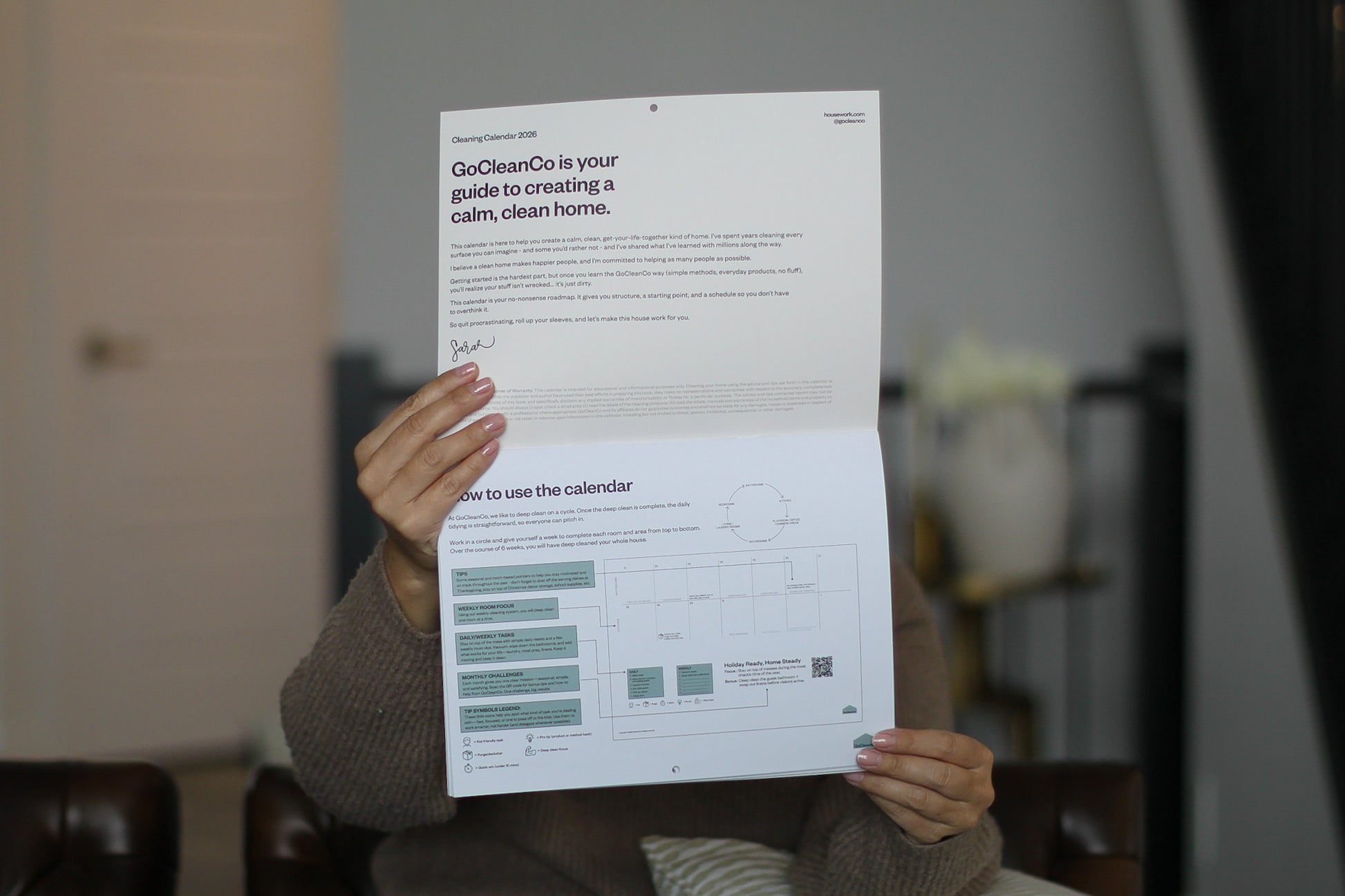 Person holding a calendar in front of their face showing the "how to use the calendar" page.