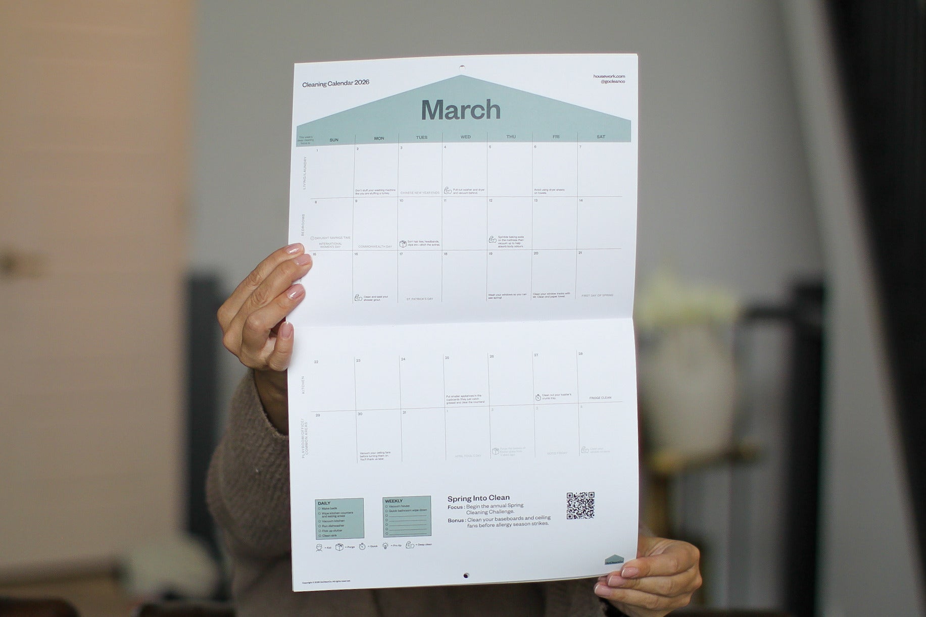 Person holding a March calendar poster in an indoor setting