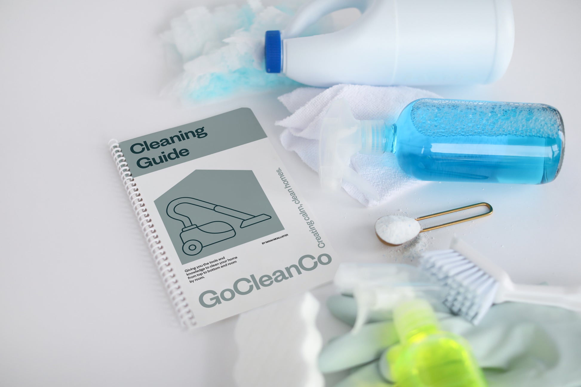 Cleaning products and a GoCleanCo cleaning guide on a light surface