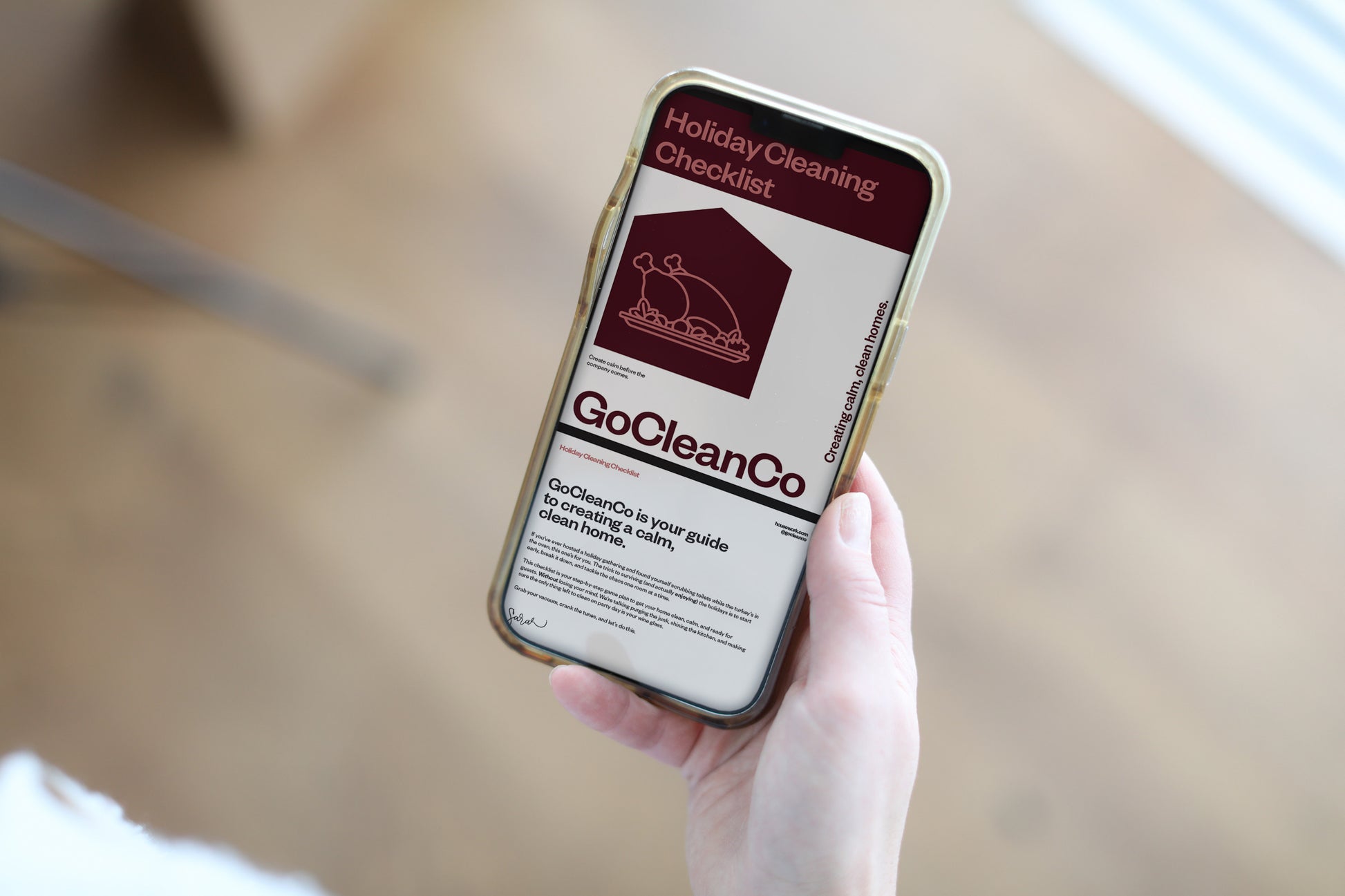 Person holding a smartphone displaying a Holiday cleaning checklist.