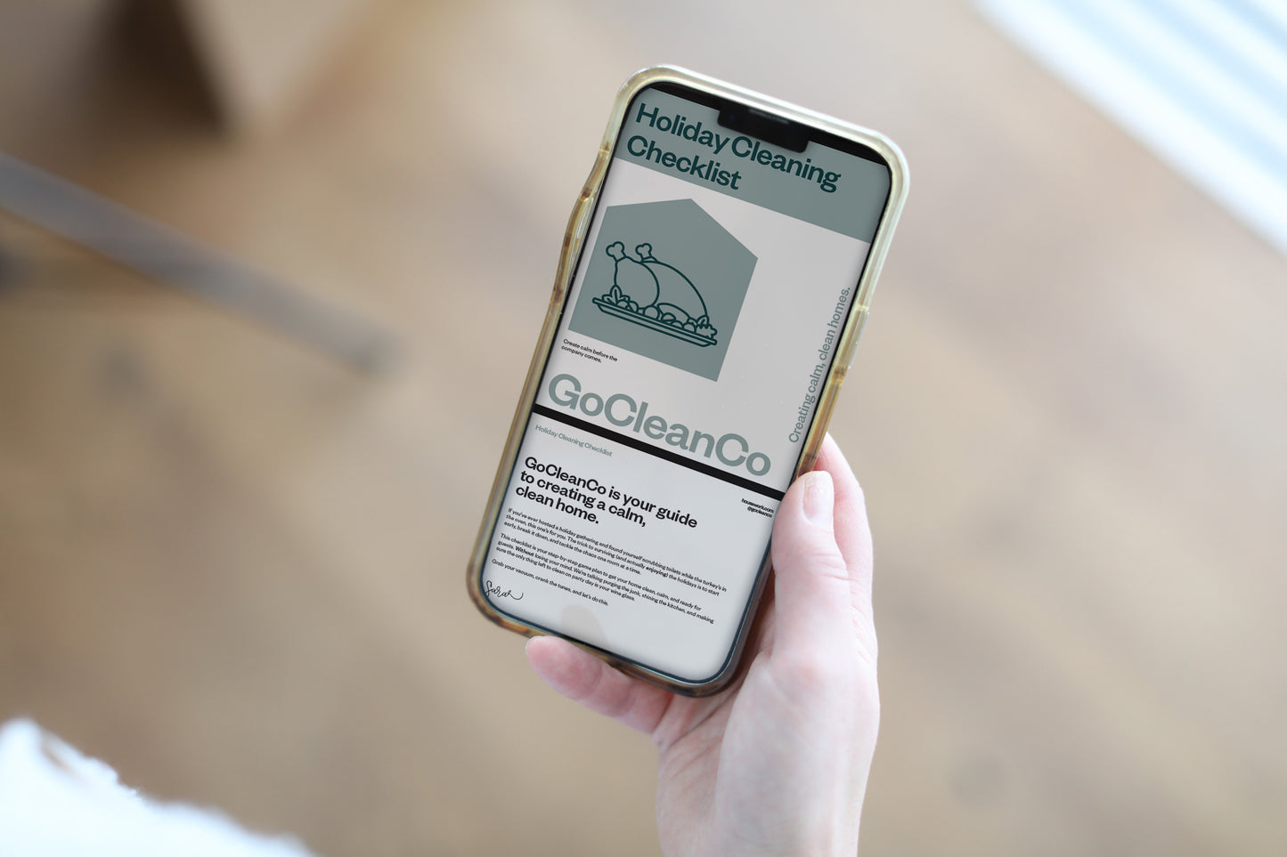 Person holding a smartphone displaying a Holiday cleaning checklist.
