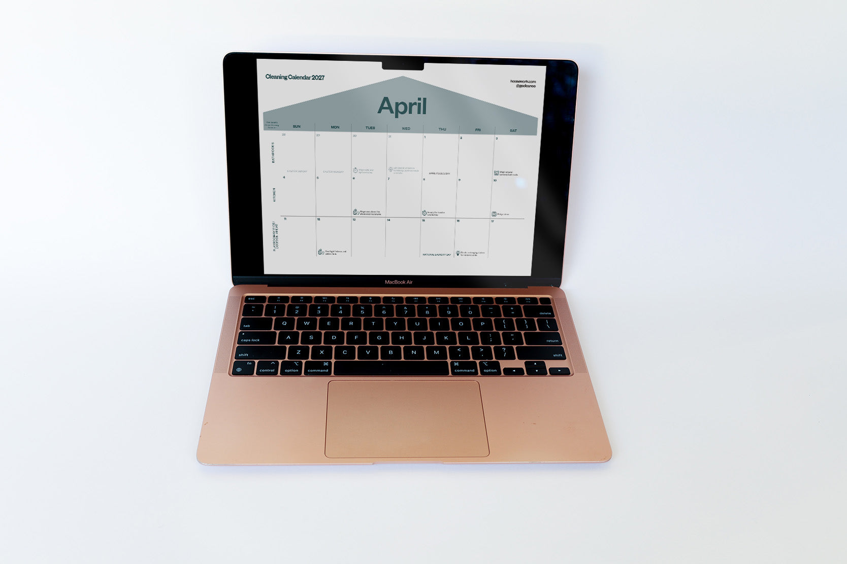 A rose gold Apple MacBook laptop is open and centered on a clean white background, displaying a digital cleaning calendar on its screen.