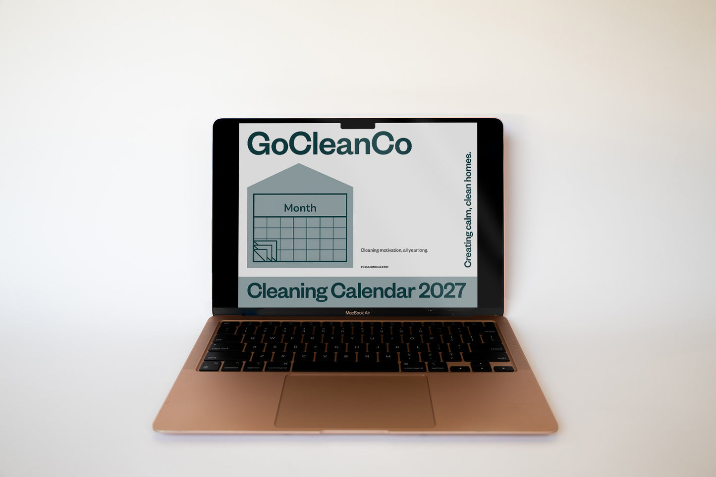 A laptop on a white surface against a white background, displaying a digital cleaning calendar for 2027 on its screen.