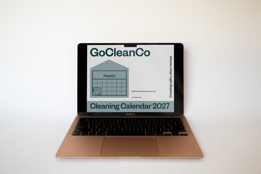 A laptop on a white surface against a white background, displaying a digital cleaning calendar for 2027 on its screen.