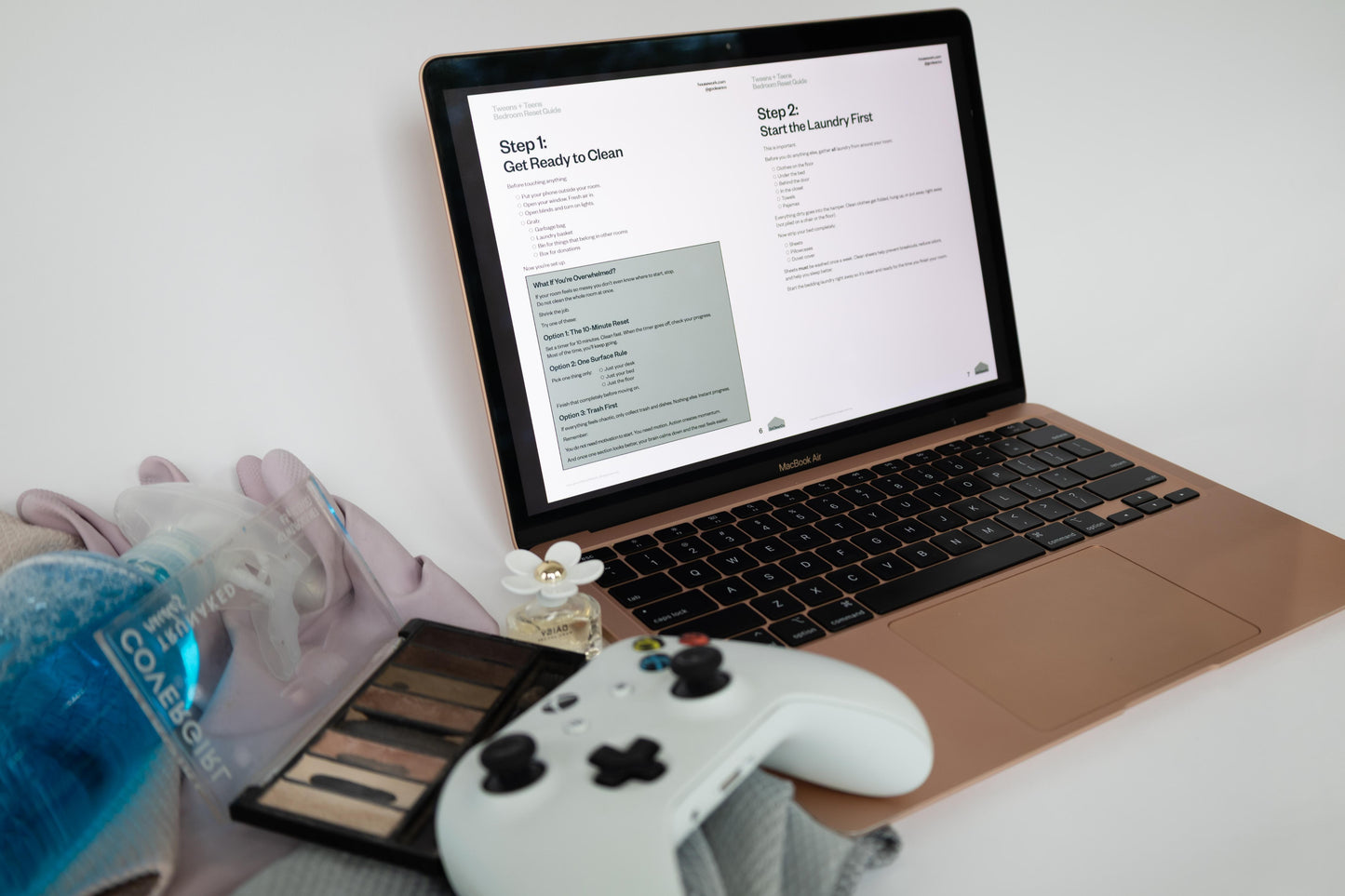 Laptop on a desk with a cleaning product, gloves, and a controller.